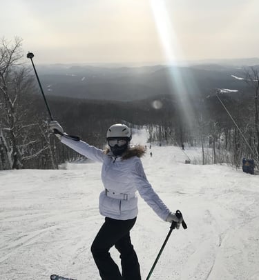 Female skier in a white jacket and helmet posing on a snowy mountain ski resort Lake Louise Canada