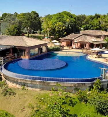 Piscina per adulti e bambini con bordo infinito e vista panoramica sulla foresta e il mare