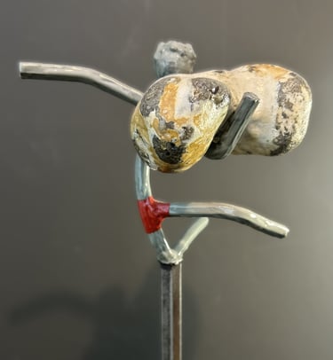 Iron sculpture with stone on iron pedestal