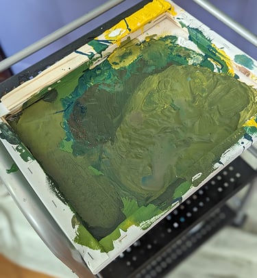 An old stretched canvas serving as a painter's pallet.