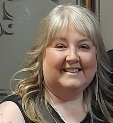 A picture of Jan Wilson wearing a black dress with a beaded neckline.