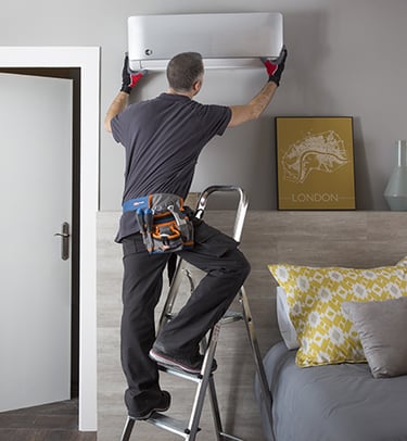 a man is standing on a ladder to reach a window