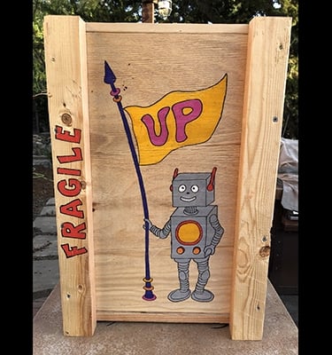 Shipping crate for Talbotics sculpture with image of rocketship drawn on it.