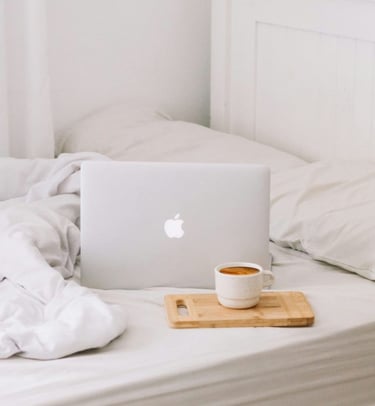 laptop on bed with coffee