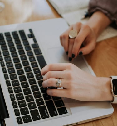a woman's hands on a laptop computer