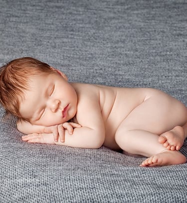a baby sleeping on a blanket on a blanket