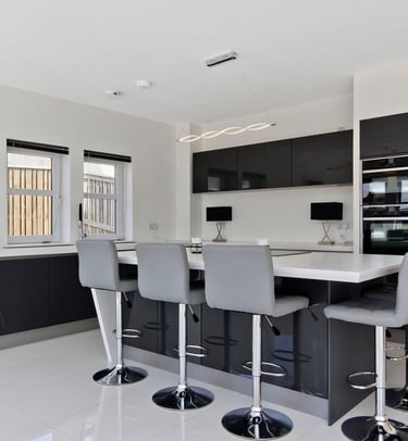 Modern bespoke kitchen with black cabinetry and large central island in East Kilbride.