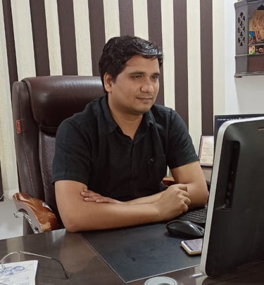a man sitting at a desk with a laptop computer