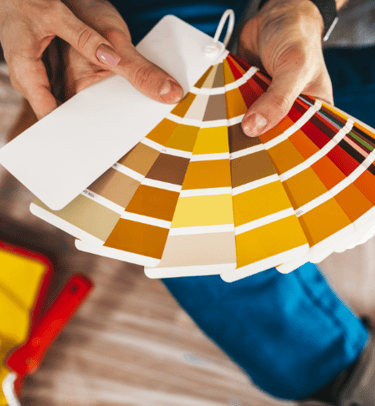 a person holding a color palette and a paintbrush