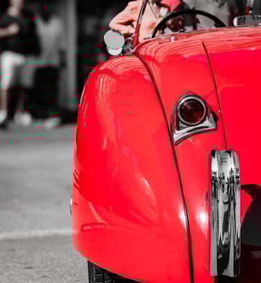 a red Jaguar with a man in a red jacket