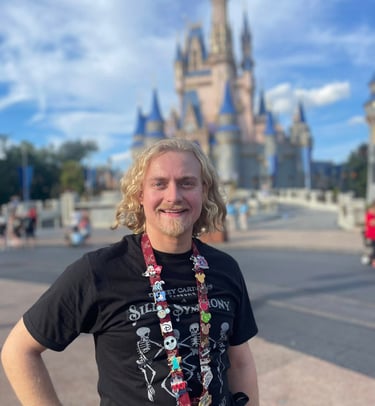 Minnie's Travel Boutique travel advisor Zach Stout pictured in front of Cinderella Castle at Disney's Magic Kingdom® Park.
