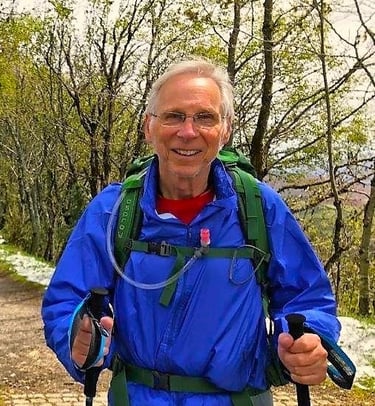 a man in a blue jacket and a backpacker