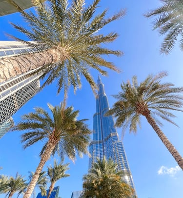 a tall building with tall palm trees in the background