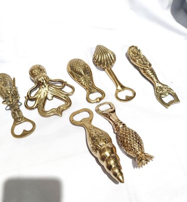 a bunch of gold colored metal objects on a white surface