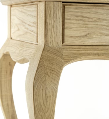 Close-up of a handmade oak console table showing the curved leg and side panel