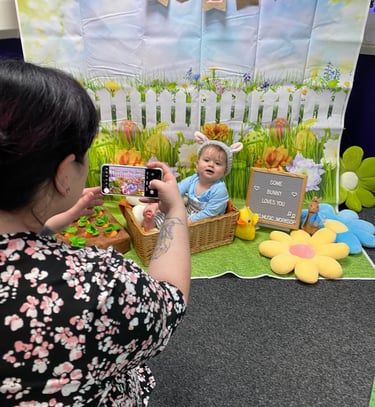 Little girl in bunny ears, in front of easter backdrop