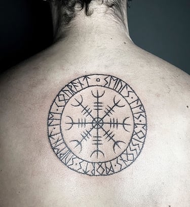 Tatouage d'un vegvisir entouré de l'alphabet runique Futhark.