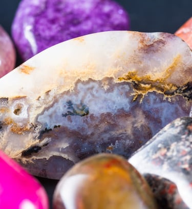 Cristales curativos de ágata y cuarzo pulidos, en vibrantes tonos morados, rosados y anaranjados.