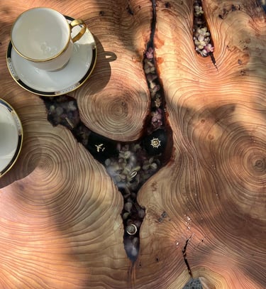 live edge epoxy tables with charms and flowers filling in the gaps where the bark used to be