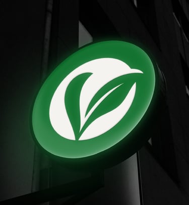 Un logo circulaire éclairé en vert et blanc avec un logo de feuilles sur une façade de bâtiment.