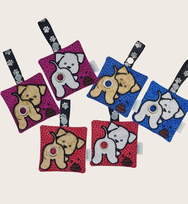 Colorful dog-themed keychains featuring plush designs, printed straps, and an embroidered poop bag holder