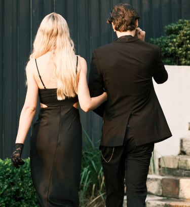 a man and woman walking down stairs in a black dress