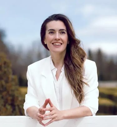 Rebeca Rueda Gallego, formadora y facilitadora experta en comunicación no verbal, sonriendo al aire libre con un blazer blanc