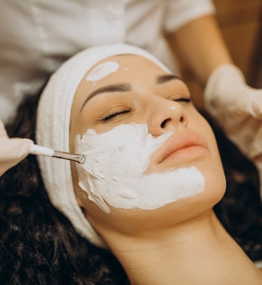 a woman getting a facial in a beauty salon