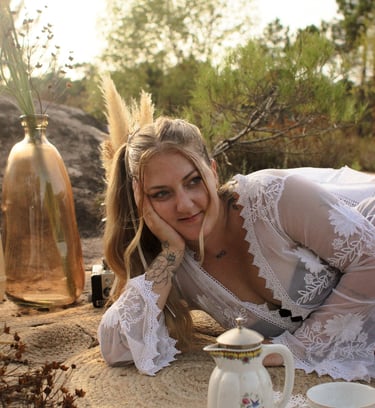 Eva Ink vlr sourit, entouré d'une théière et d'un vase, dans une lumière chaude