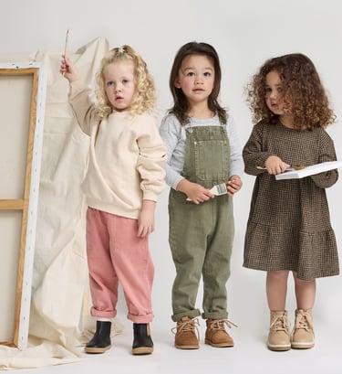 Fashion campaign photography - three young children standing in front of a white canvas