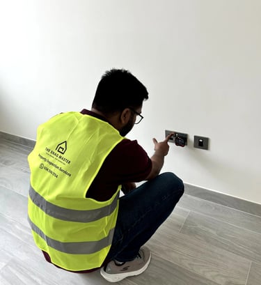 Engineer testing electrical socket for voltage and safety compliance during villa inspection