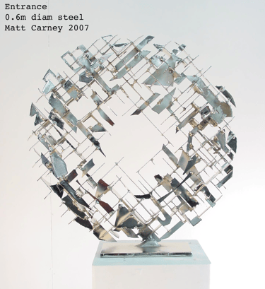 a silver cross-hatched circle sculpture  