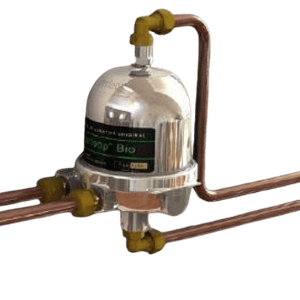 Polished silver magnetic central heating filter connected to copper plumbing pipes for boiler system protection.