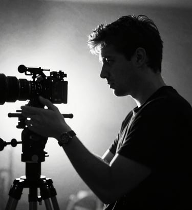 A high-contrast black and white portrait of a filmmaker in action, silhouettes against a bright light source. Strong #0A0A0A shadows and #ECF0F1 highlights. Grainy, filmic texture, very professional and artistic.