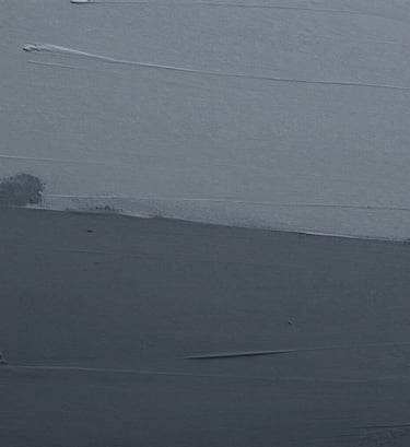 Macro photography of an artistic surface showing subtle transitions of grey and dark grey paint, emphasizing a minimalist and serene mood in a European context.