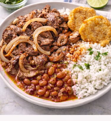Puerto Rican bistec encebollado steak with onions served with white rice, stewed red beans, and tost