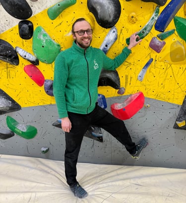 a man standing in front of a climbing wall