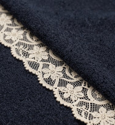 A detailed close-up of premium fabric textures, showcasing a mix of dark charcoal blue wool and delicate cream lace, captured with high-end editorial lighting in a North American / Western European fashion atelier.