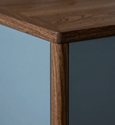 Photography of a custom-designed furniture detail in a Northern European home. Focus on the seamless joint of dark oak wood and soft blue lacquer. Minimalist, professional close-up with soft cinematic shadows.