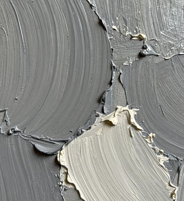 A close-up, macro photograph focusing on the heavy texture and impasto brushwork of an oil painting. The palette includes shades of medium grey and off-white. Soft, natural light highlights the depth and ridges of the paint layers on the canvas.