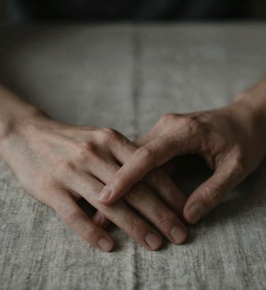 An artistic close-up shot focusing on the emotional depth of two hands barely touching on a rustic linen surface. The style is moody and sophisticated, using the palette colors #6F604F and #262626. The lighting is low-key, emphasizing texture and a feeling of connection.
