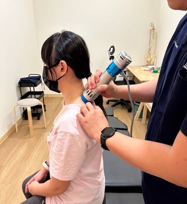 Shockwave therapy on upper back at Sinisana Chiropractic clinic.