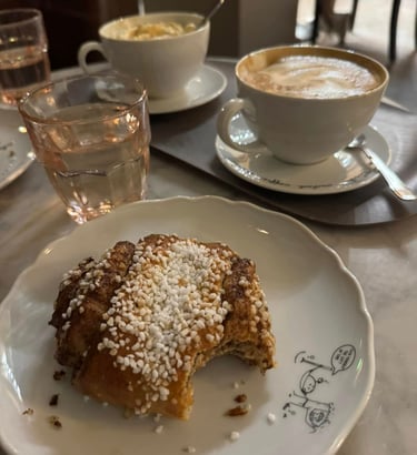 a coffee and a pastry with a bite taken out of it