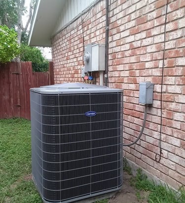 a large air conditioner sitting on the side of a brick building