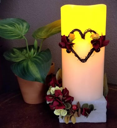 a candle with a heart and flowers