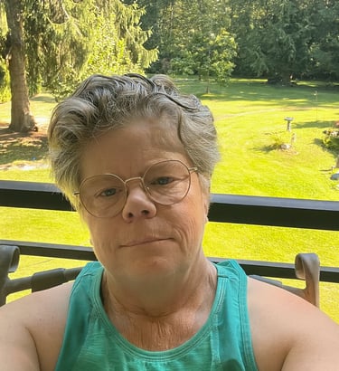 Author photo   Author and wellness coach Kerisma Vere smiling in front of green space