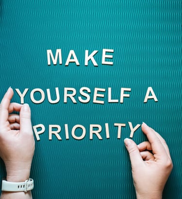 Make yourself a priority motivational quote with wooden letters on a teal yoga mat for self-care.