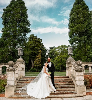 a bride and groom standing on a stone staircase