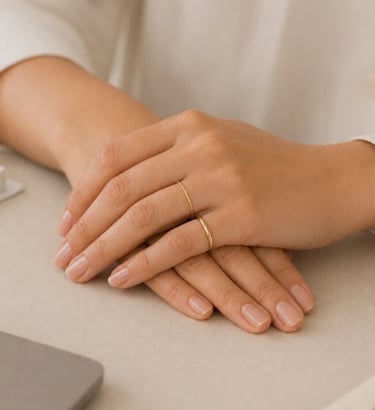 Minimal hand jewelry with simple gold ring and thin band on natural nails