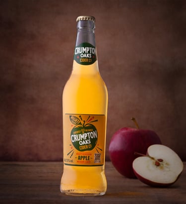 Bottle of Cider with apples in the background